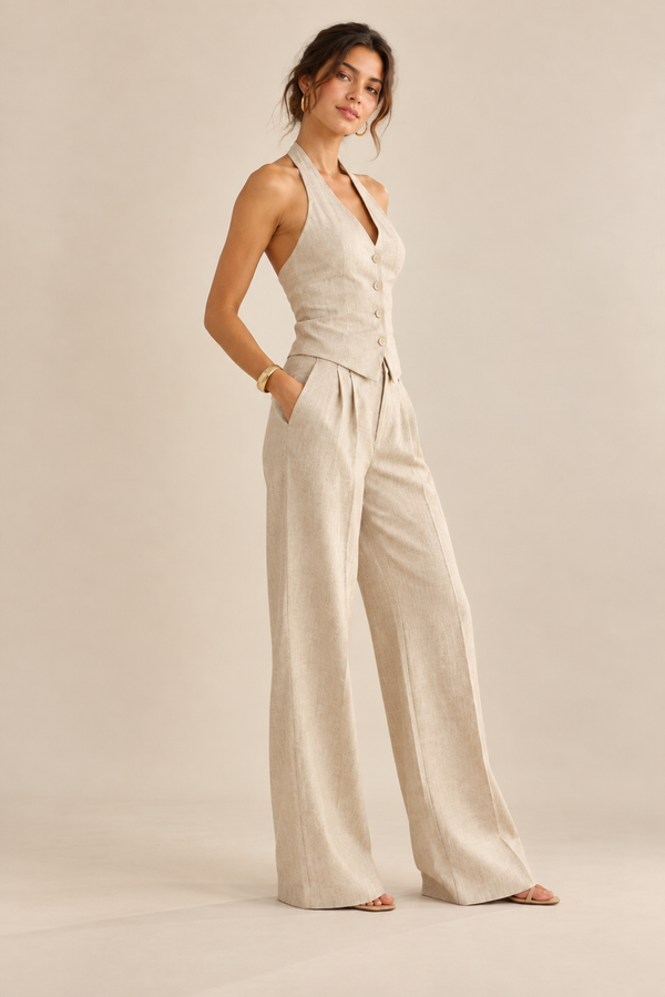 Side view of beige halter waistcoat and pleated wide-leg trousers