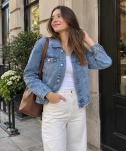 Light-wash cropped denim jacket styled with cream trousers