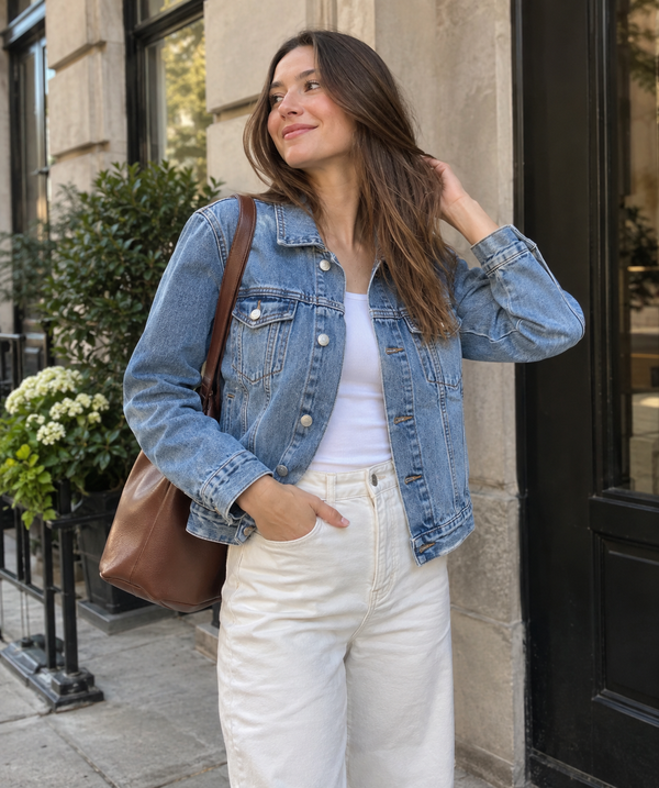 Light-wash cropped denim jacket styled with cream trousers