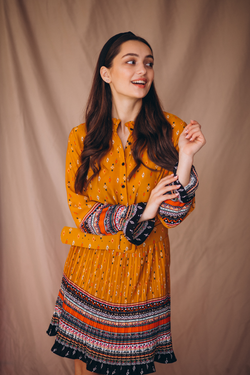 Model wearing a mustard orange printed long-sleeve belted dress